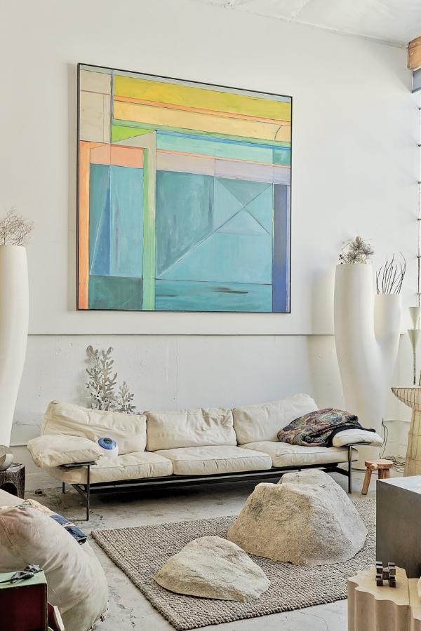In Pessin’s living room, a circa 1970s–80s painting inspired by the Richard Diebenkorn “Ocean Park” series hangs over a 1970s B&B Italia Diesis leather sofa and three fibreglass faux boulders. Photography by Philip Cheung.