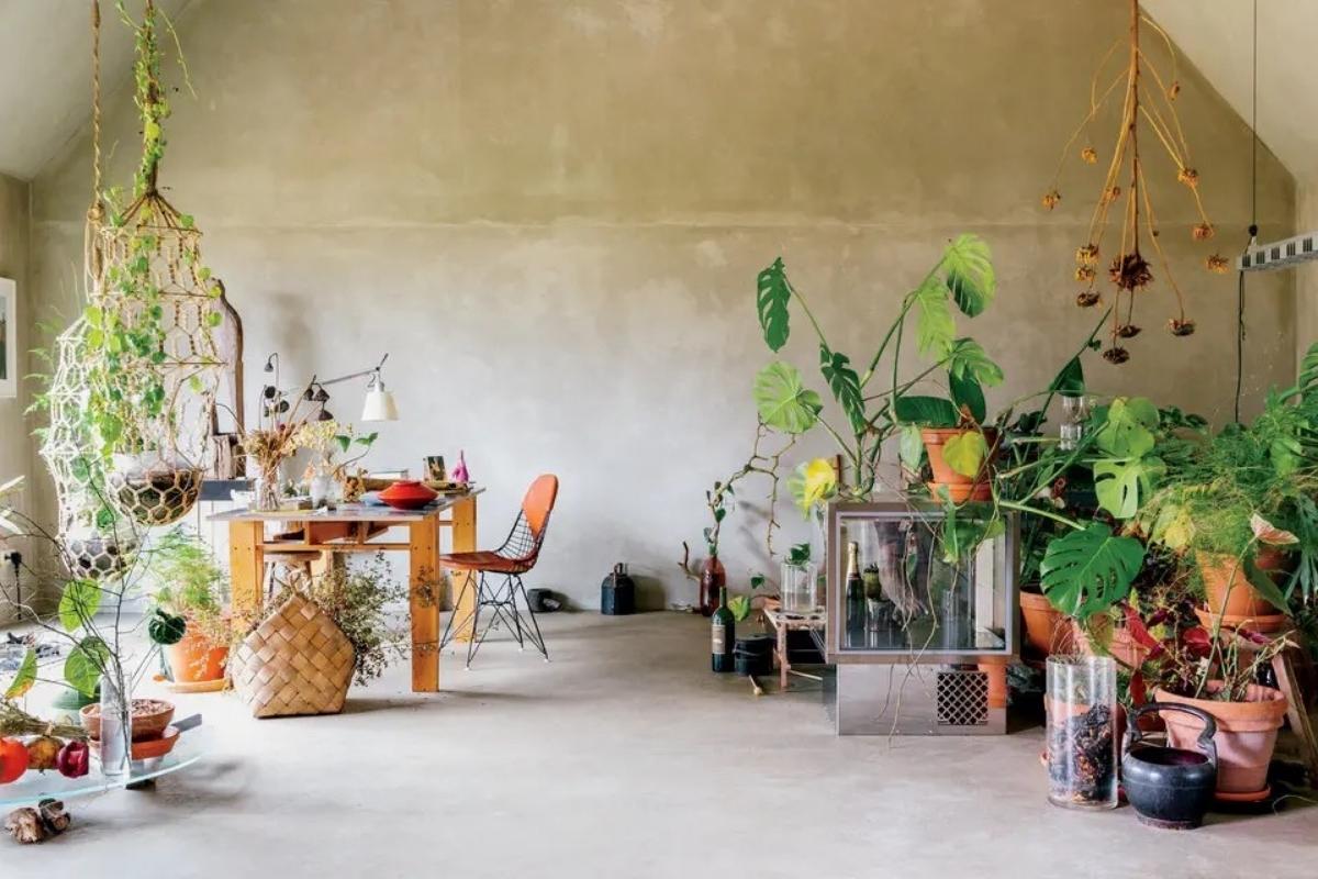 In the artist Danh Vo’s living room at his farmhouse in Brandenburg, Germany, potted and hanging plants, both living and dried; a leather-covered wire chair by Charles and Ray Eames; and a table Vo built according to the Italian designer Enzo Mari’s “Autoprogettazione?” (1974), a manual of furniture designs that can be made using simple materials and tools. Photography by Angela Simi.