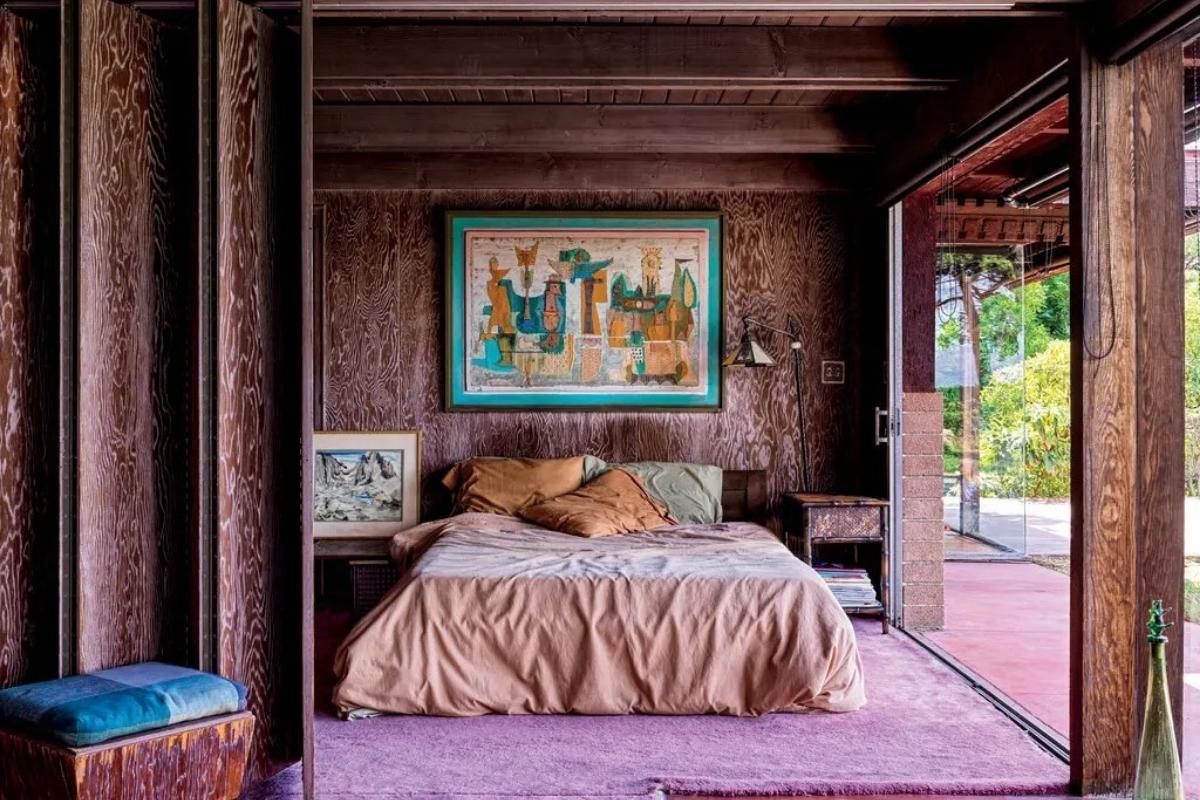 Another painting by Varda hangs in the bedroom, which is separated from the living room by a folding partition. Double sliding glass doors open onto the backyard and pool. Photography by Chris Mottalini.