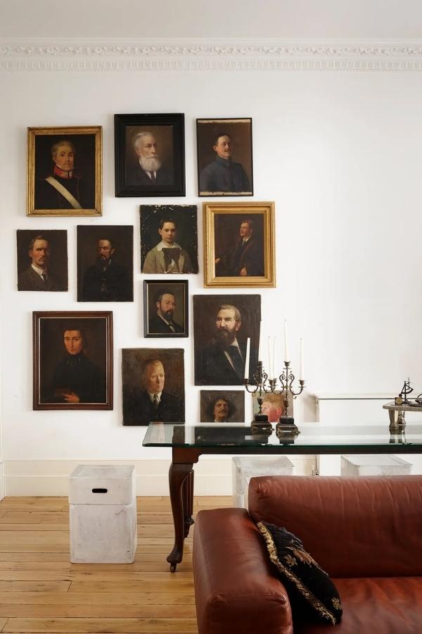 Beside a glass-topped dining table of Karavil’s own design, a collection of anonymous portraits picked up from markets and antiques fairs across Europe. Photography by Simon Upton.