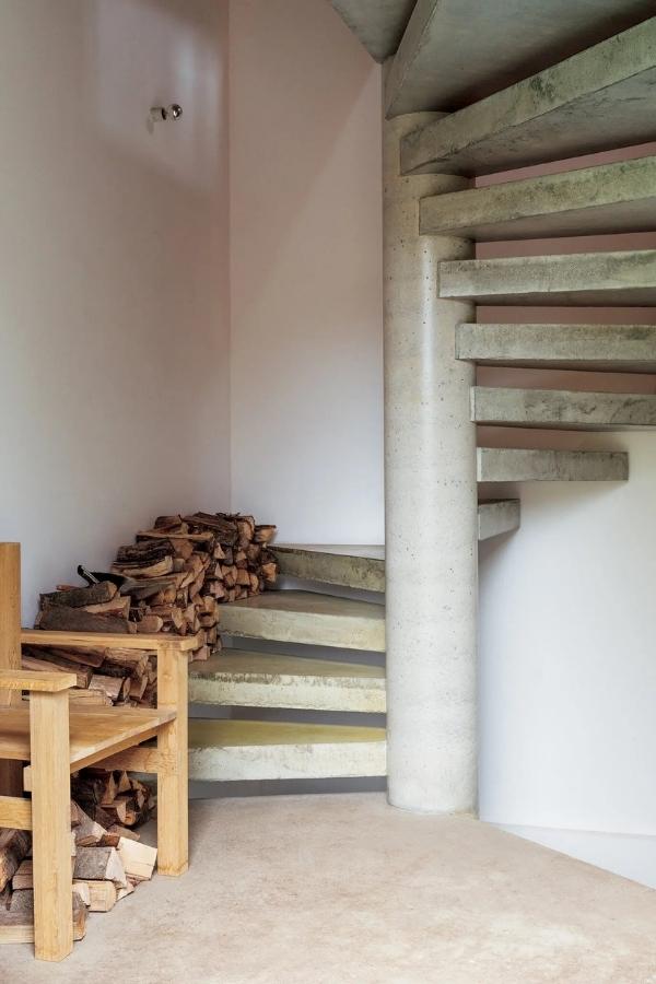 A stairway from the office/lounge where firewood is collected. The entire farmhouse is heated with firewood sustainably sourced from a protected nature preserve nearby. Photography by Angela Simi.