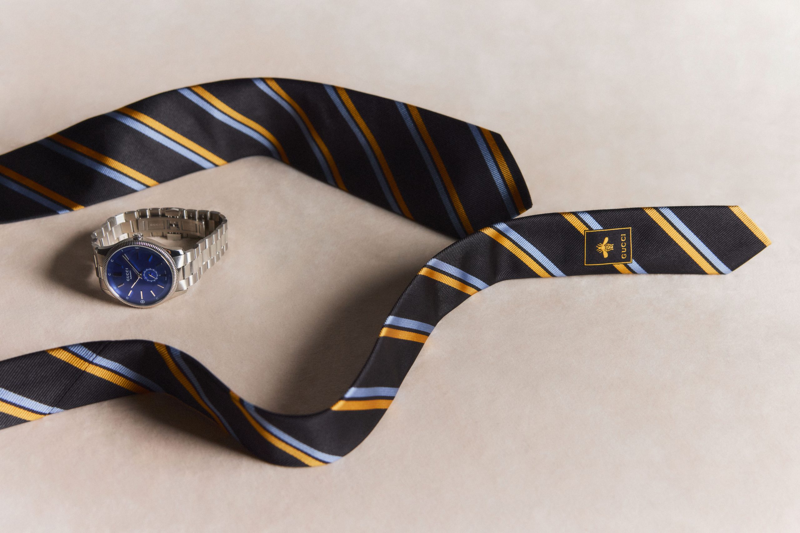241111_TMAG_07_0169 Gucci jacquard silk tie, $400; and G-Timeless 40mm watch, $3,750.